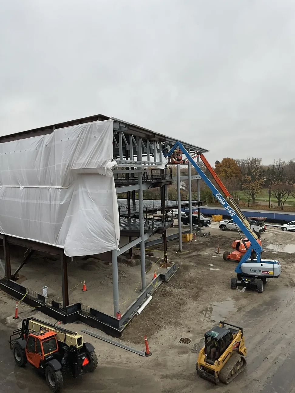 Aurora University Learning Commons: the frame partly wrapped for weather, with lifts and equipment around it