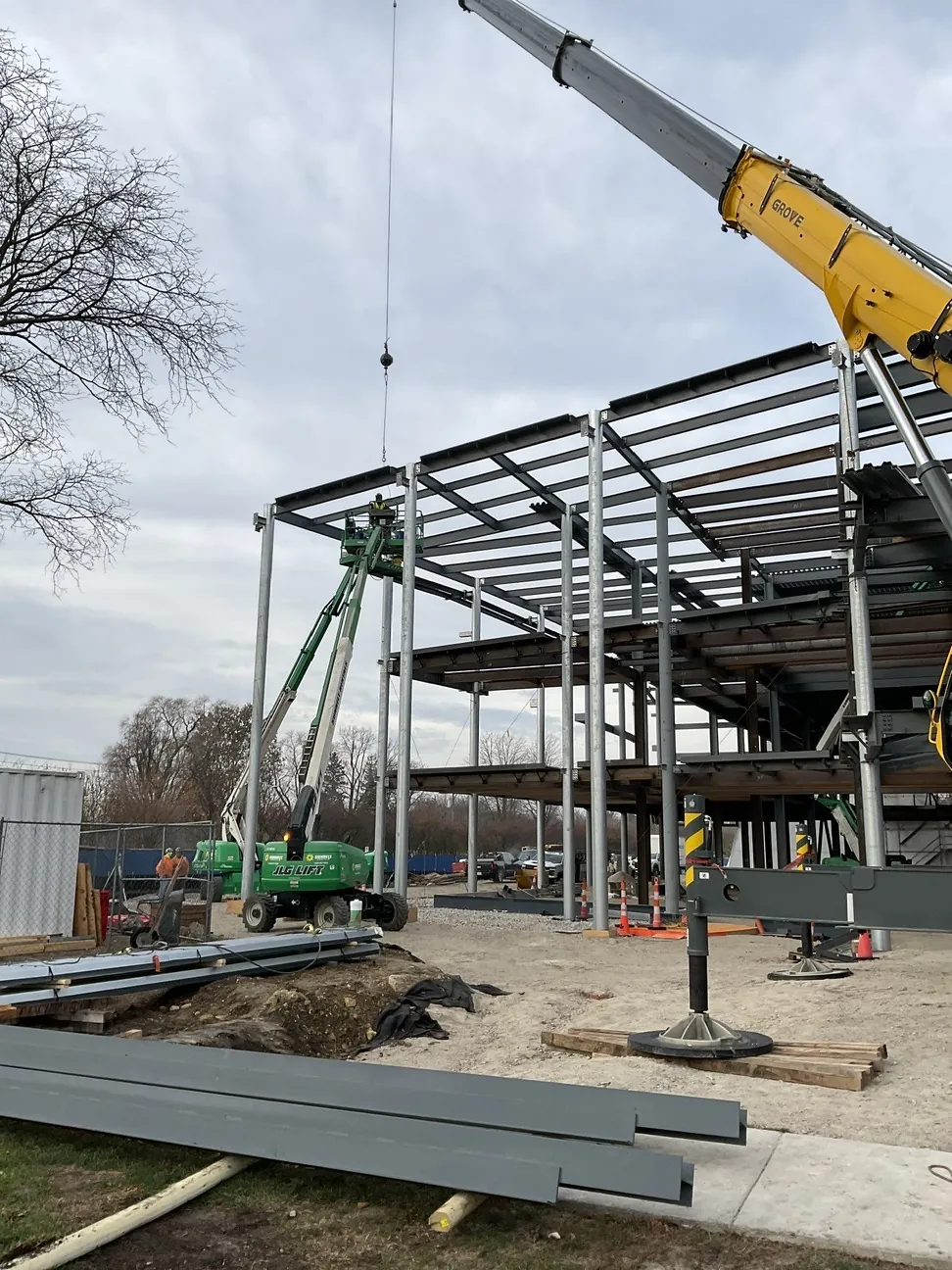Aurora University Learning Commons: a crane lifting steel onto the frame, with boom lifts at work