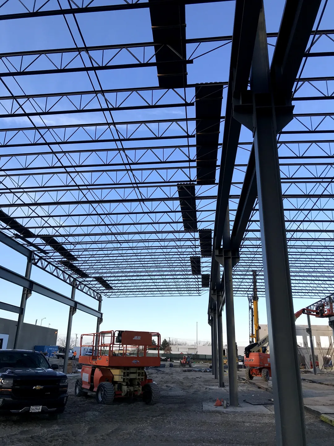 Bulldog Cartage: a column line under the roof joists, with a scissor lift parked beside it