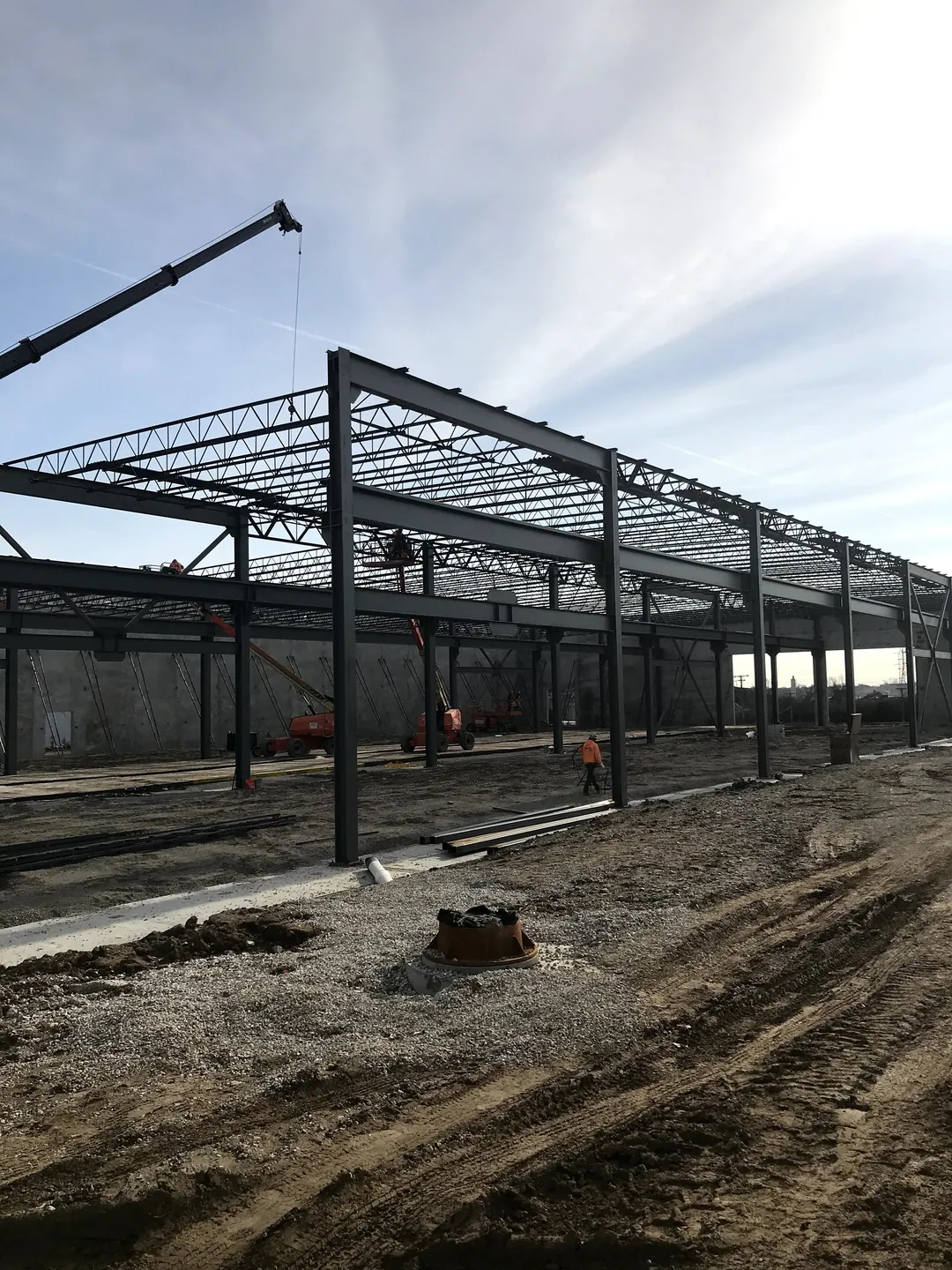 Bulldog Cartage: a crane setting steel at the open end of the building