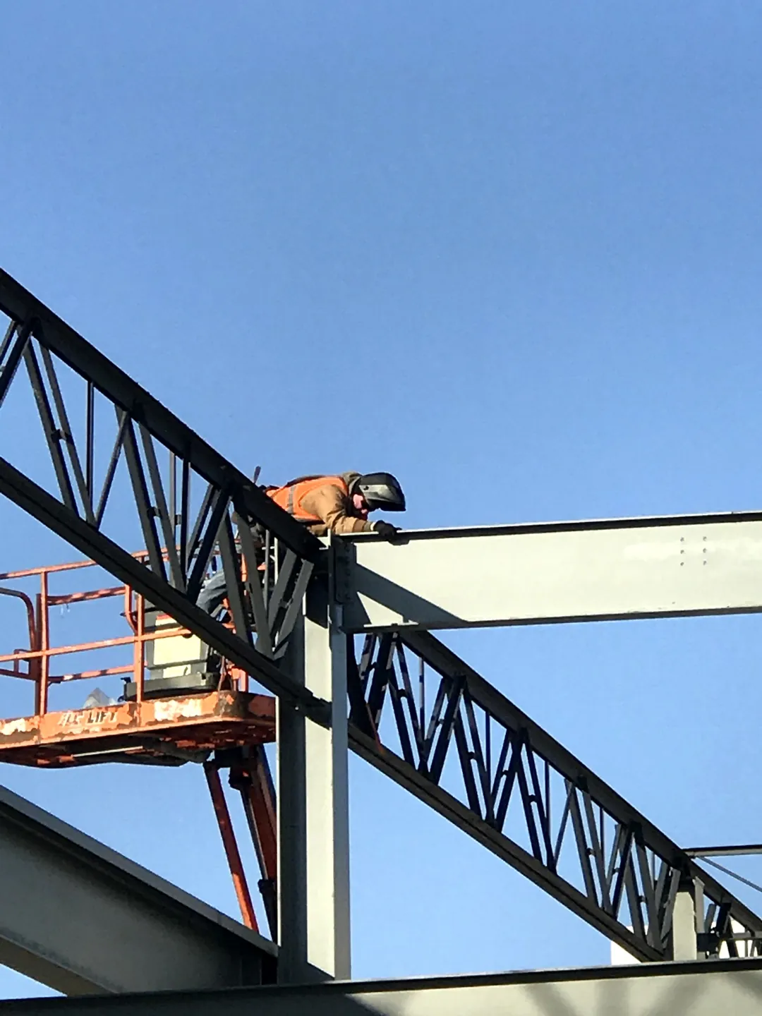 Bulldog Cartage: an ironworker on a lift welding at a column