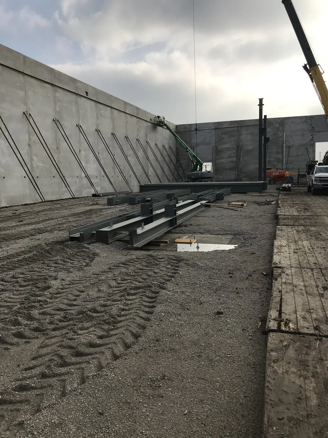 Bulldog Cartage: columns and beams staged along the braced tilt-up walls, with a crane boom in view