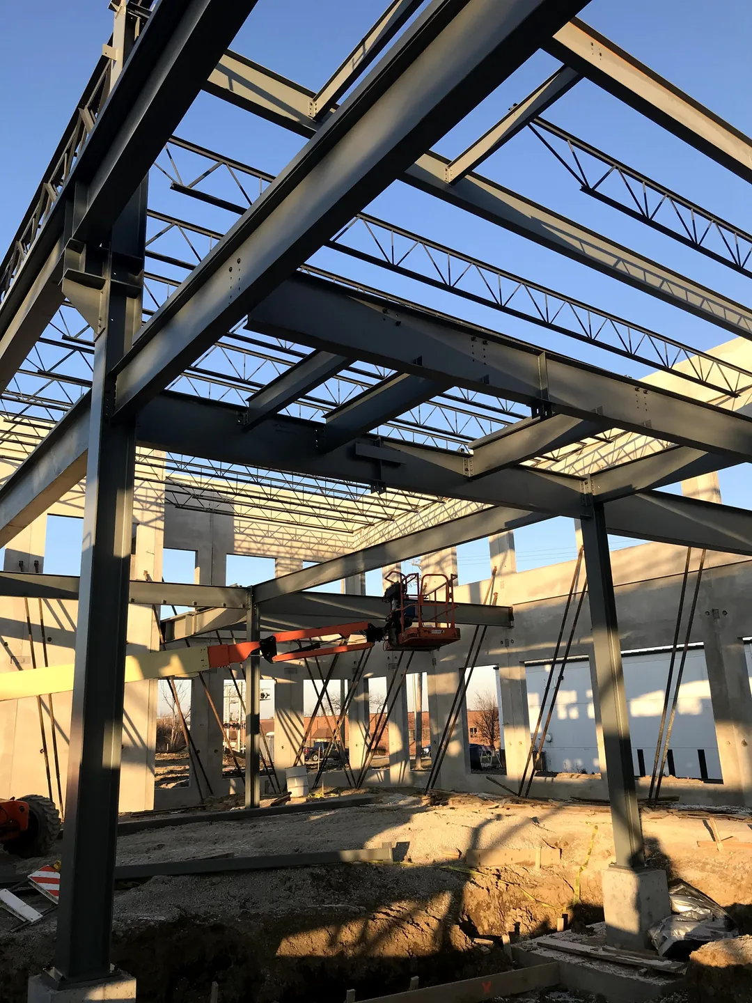 Bulldog Cartage: office-area framing with beams and joists, and a worker on a lift