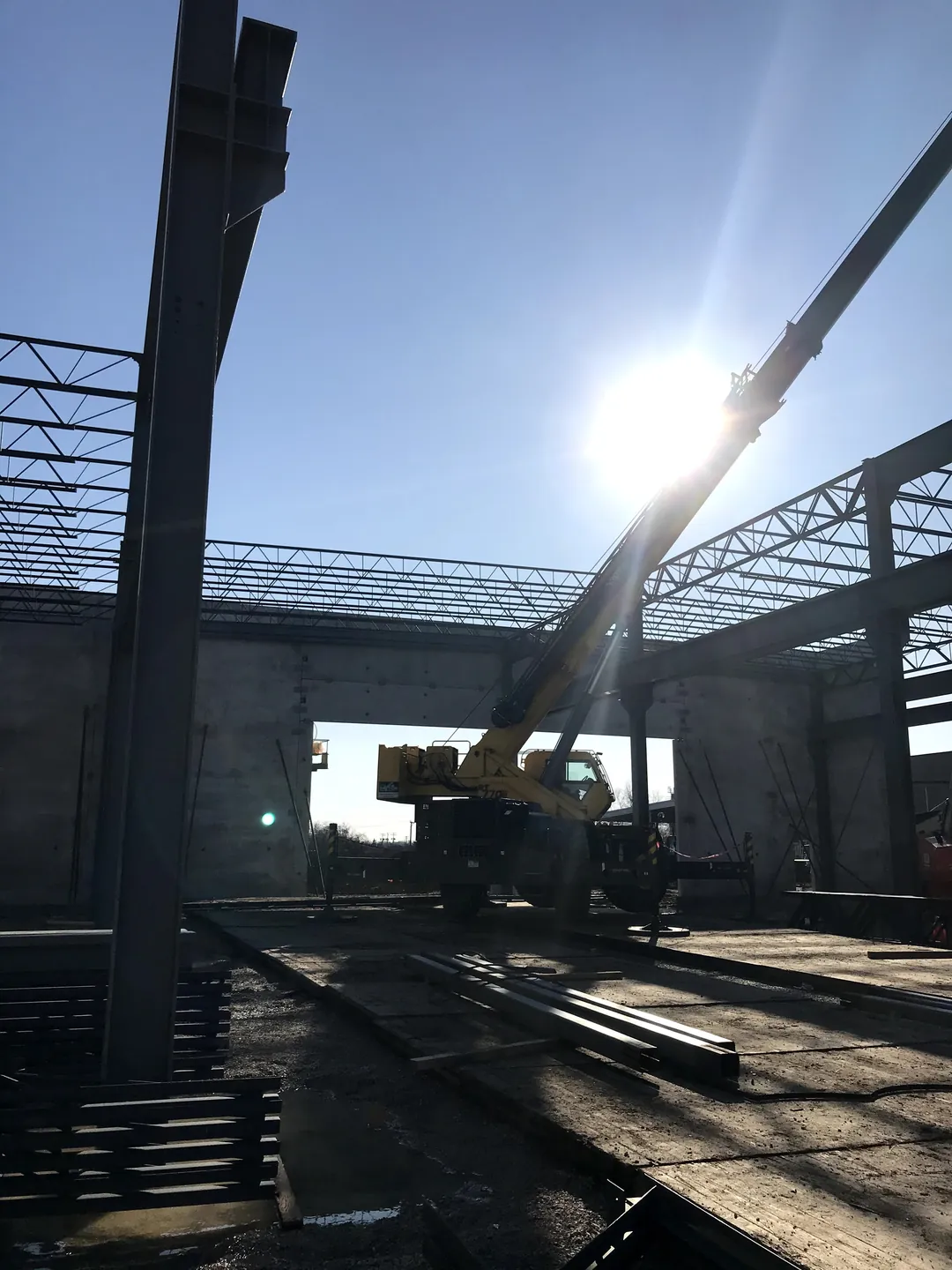 Bulldog Cartage: a column and a crane setting roof joists over the building