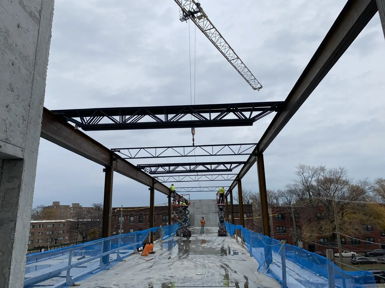 Project HOOD: steel trusses and beams over the concrete deck, with a tower crane above