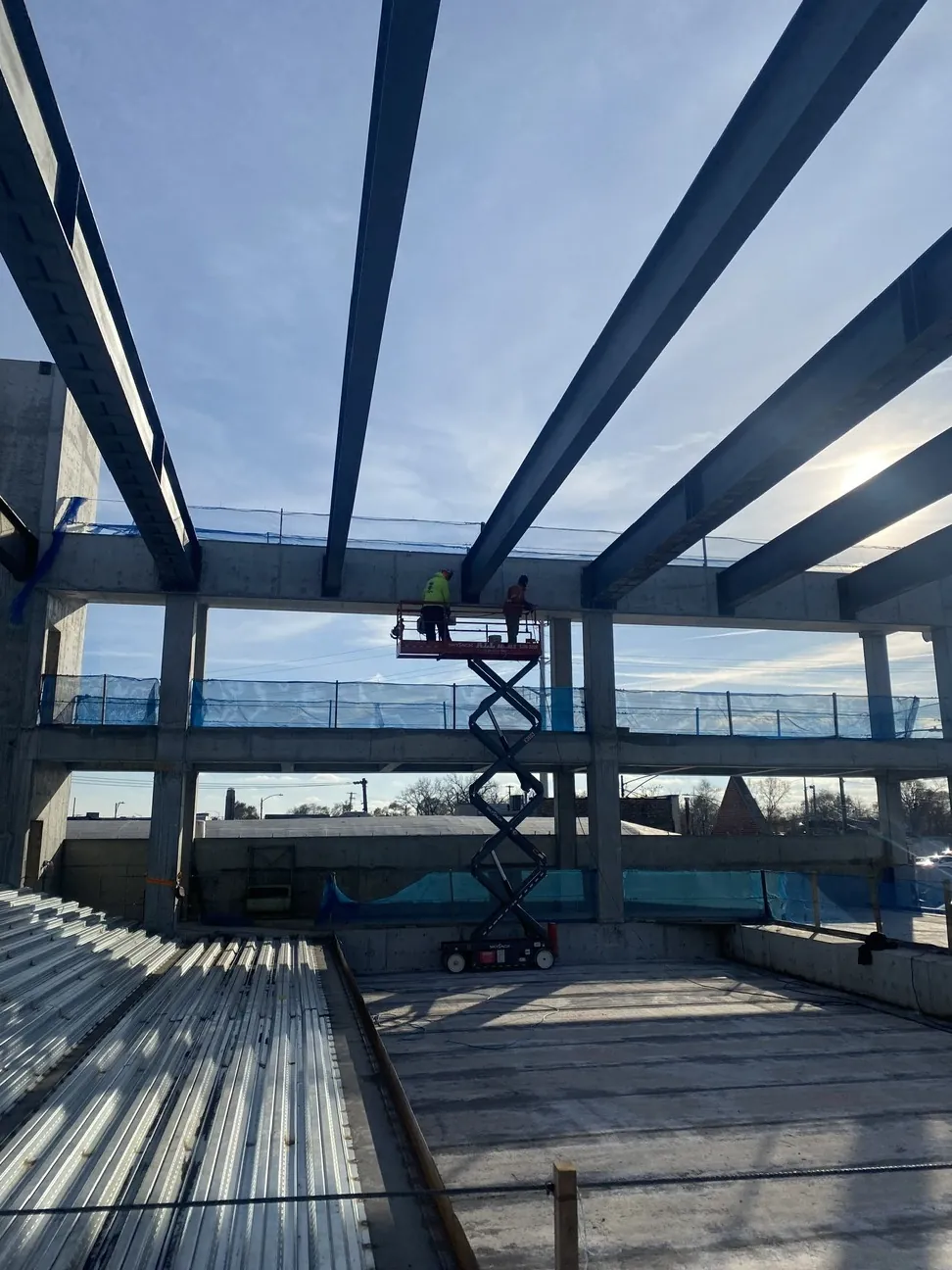 Project HOOD: beams over the concrete frame, with a scissor lift at work