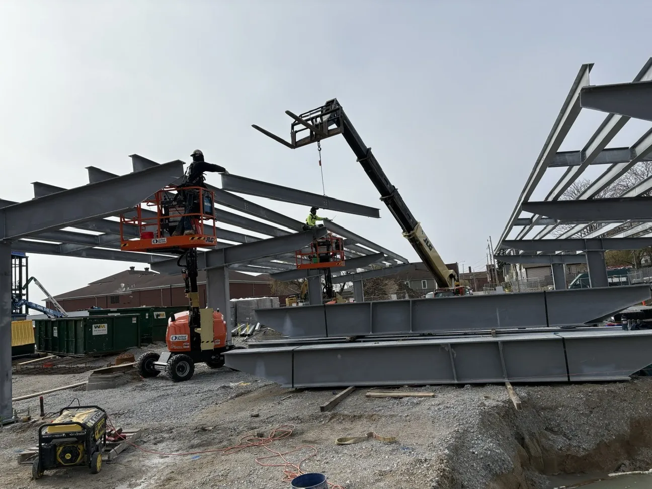 Lincoln King Center: ironworkers on lifts connecting the cantilevered roof beams