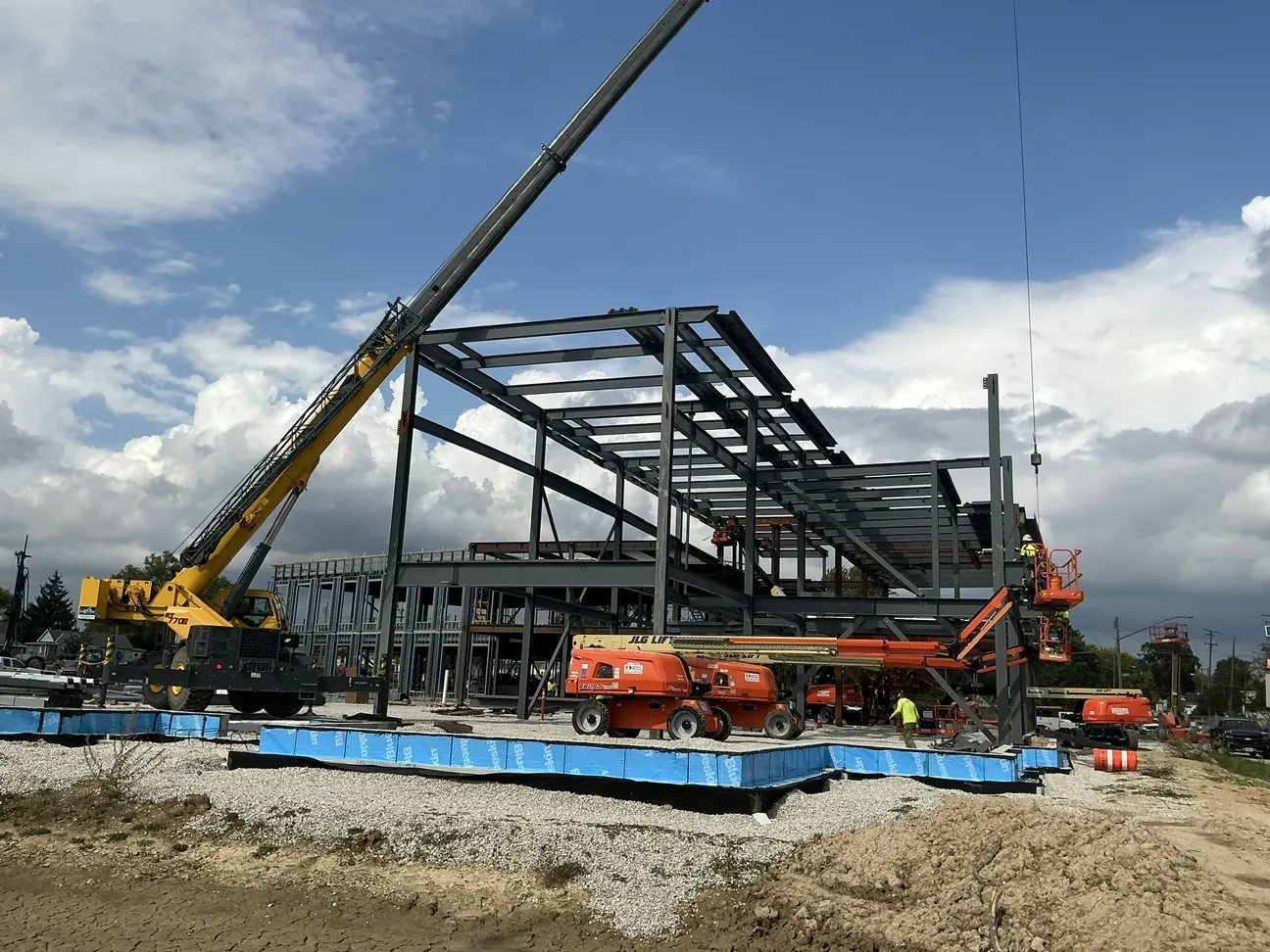 Lincoln King Center: a crane and boom lifts setting steel on the upper levels