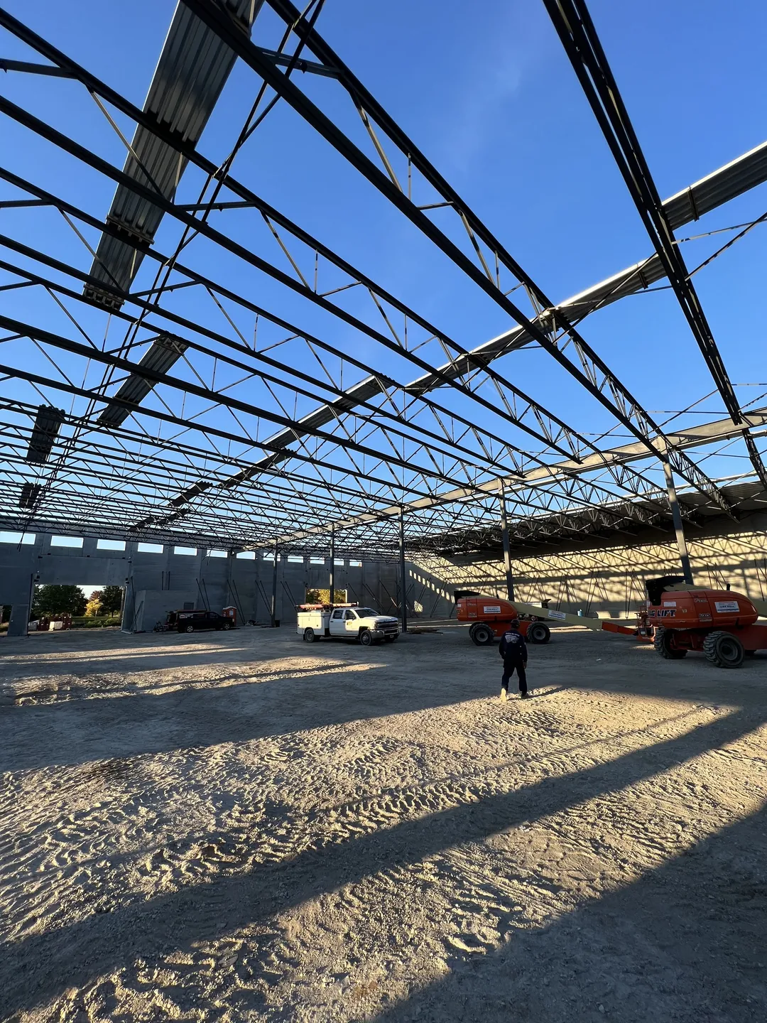 Montgomery Public Works: the roof framing over the open floor, with boom lifts at the far wall