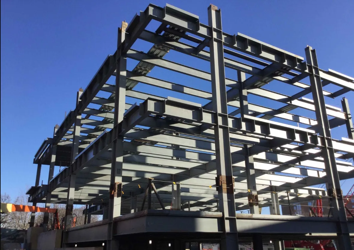 Midwestern University Support Services Building: looking up at the multi-story steel frame against a blue sky