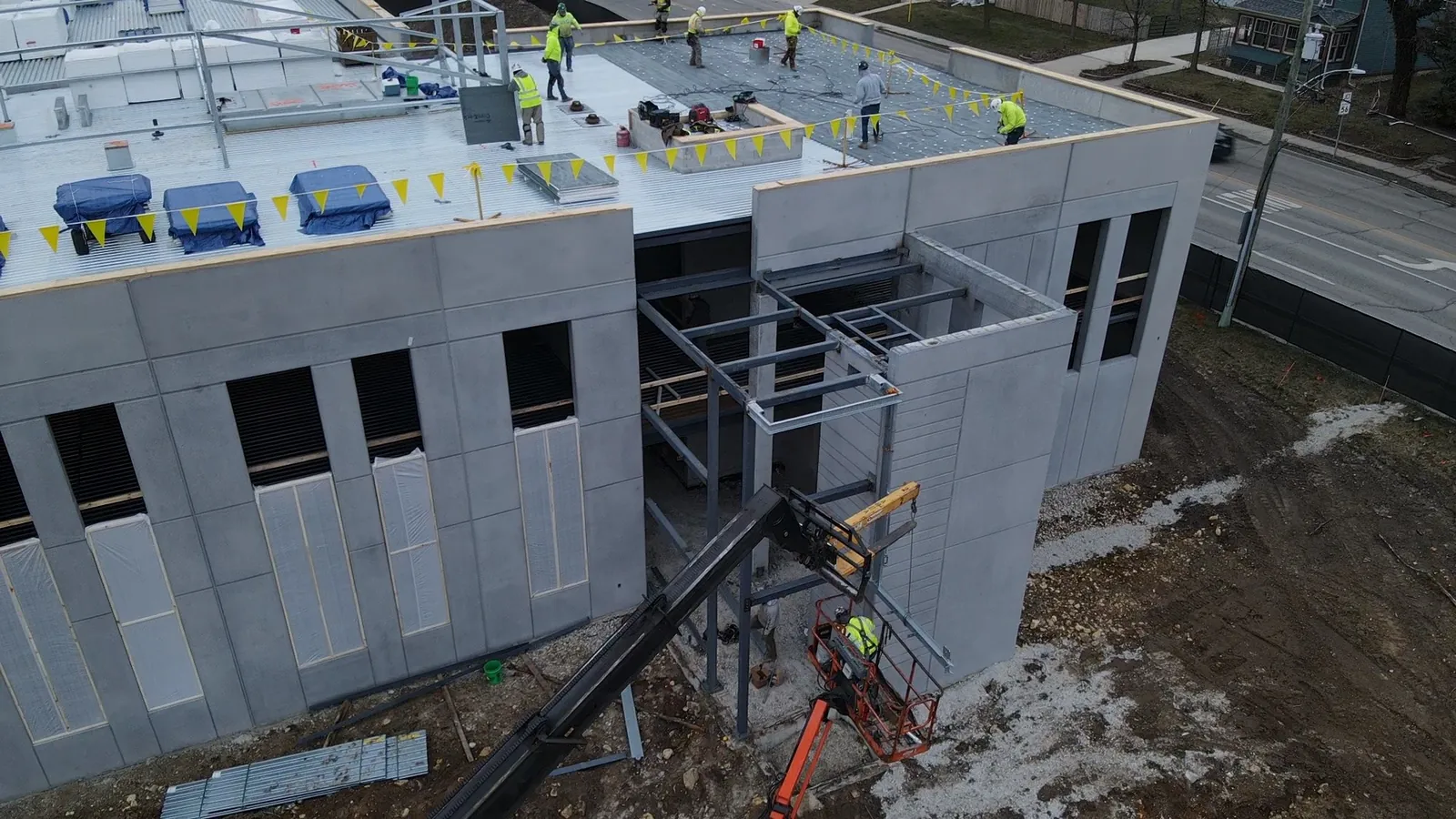 North Aurora Fire District Headquarters: aerial view of the corner steel frame, with the roof crew at work