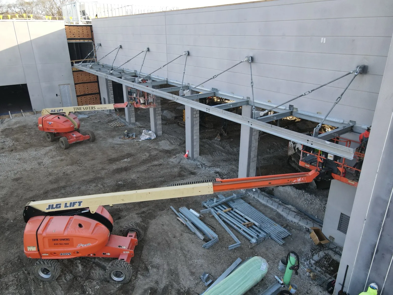 North Aurora Fire District Headquarters: canopy steel hung from the precast wall on tie rods, with boom lifts below