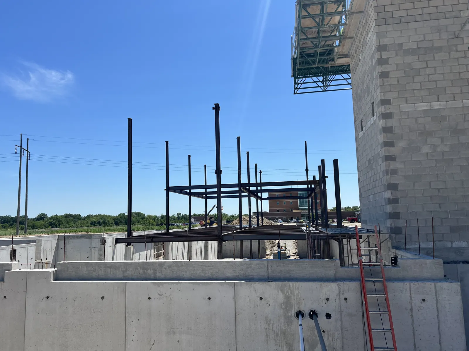 Northwest Community Cancer Center: steel framing rising inside the foundation walls, next to the masonry tower
