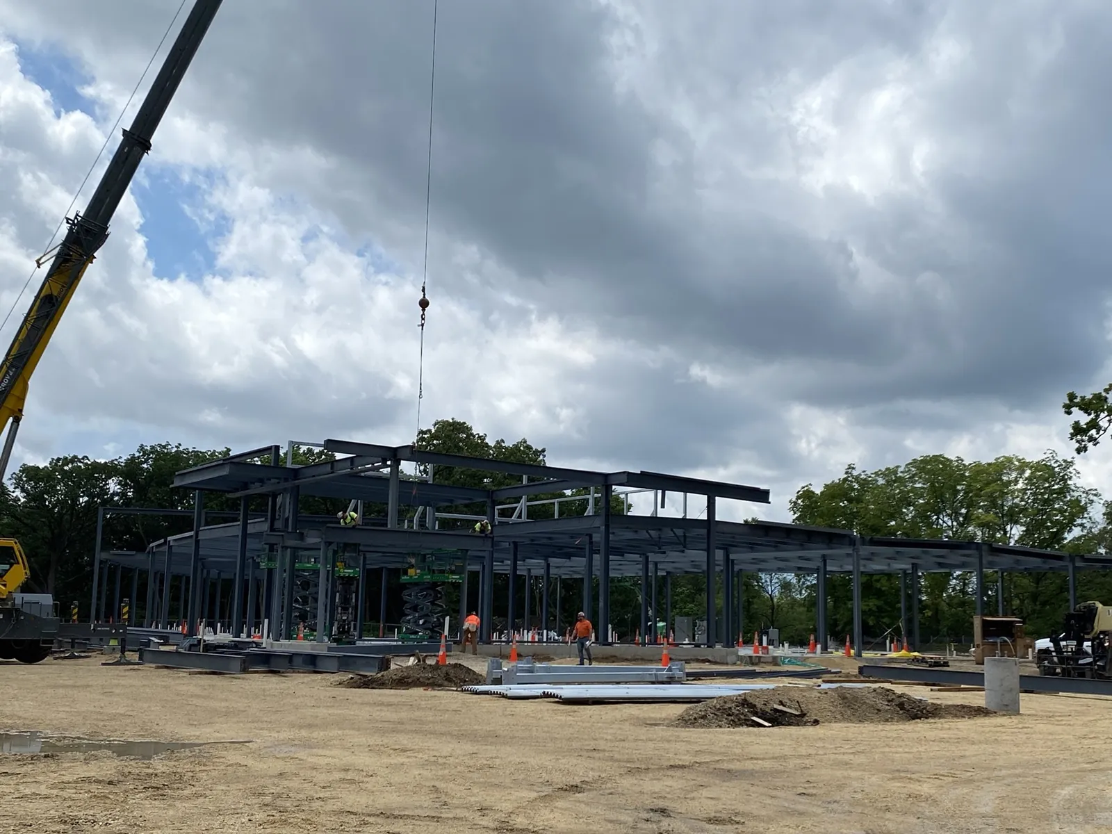 OrthoWisconsin Ambulatory: the one-story steel frame going up on a wooded site, with a crane at left