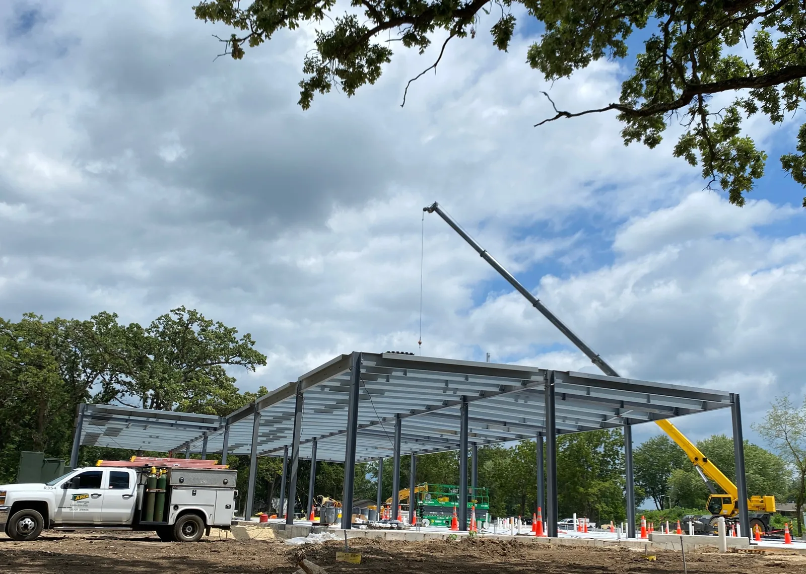 OrthoWisconsin Ambulatory: a crane setting steel on the frame beside the tree line