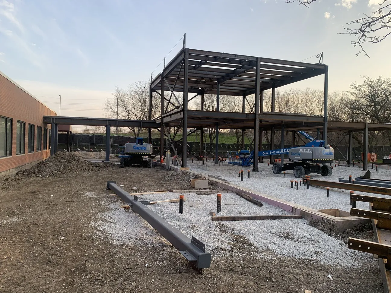 TCA Health: the steel frame beside the existing brick building, with boom lifts on site