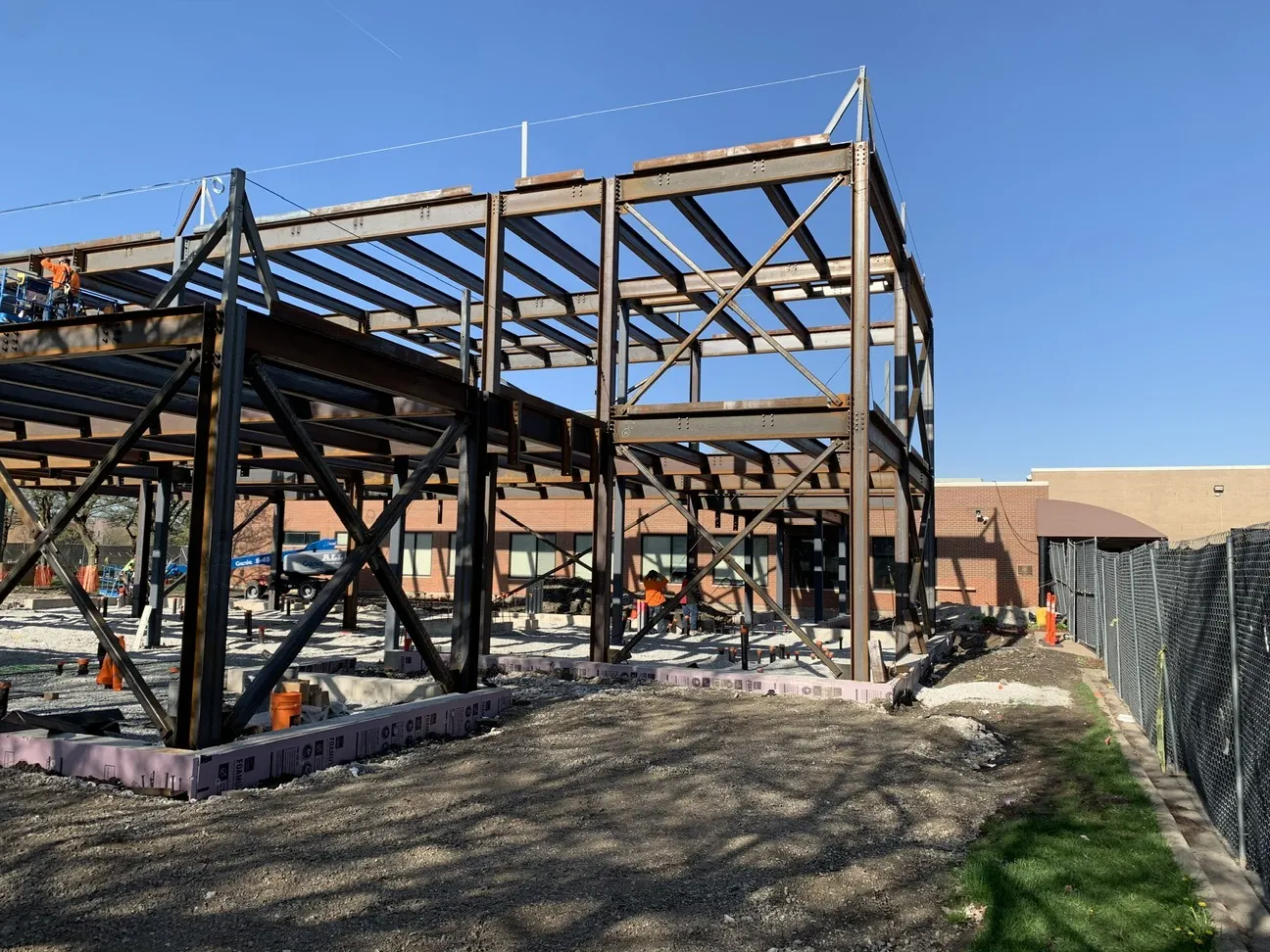 TCA Health: the braced steel frame against a blue sky, with the existing building behind