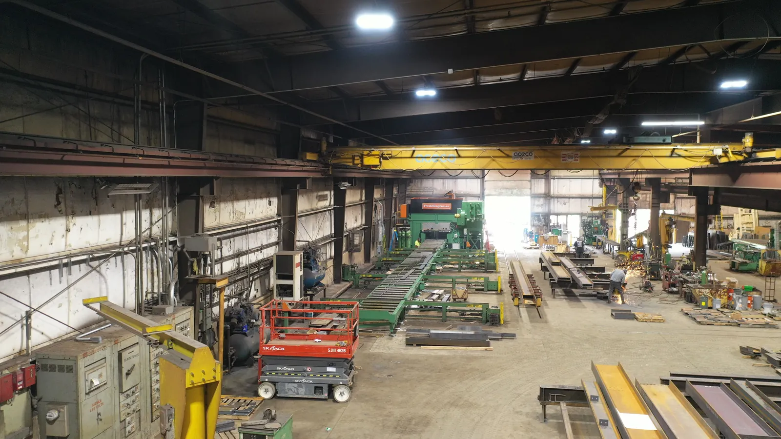 Fabrication bay with the Peddi-Bot 1250 ST line at the far end and an overhead bridge crane