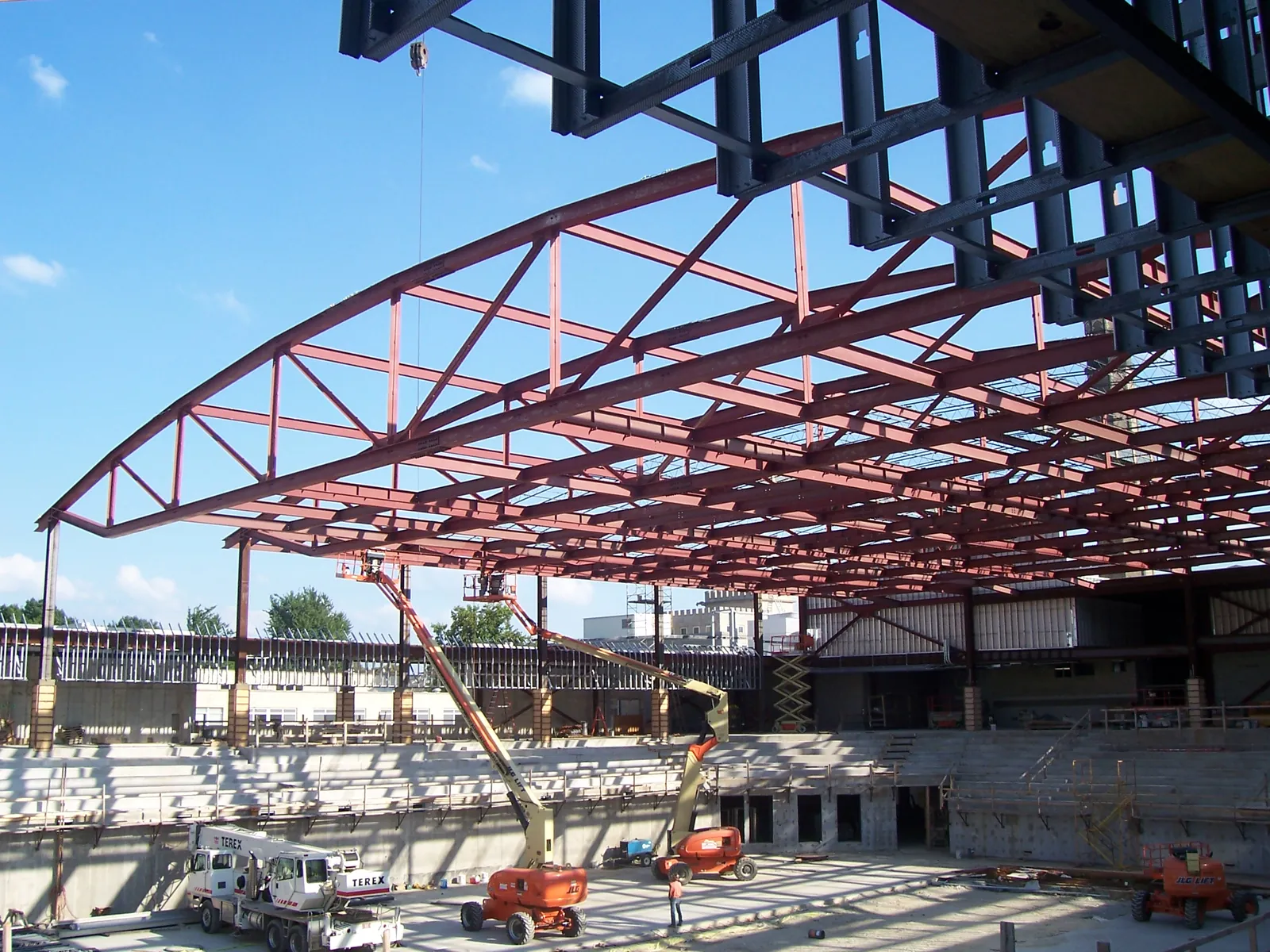Red-primed arched steel trusses set over an arena