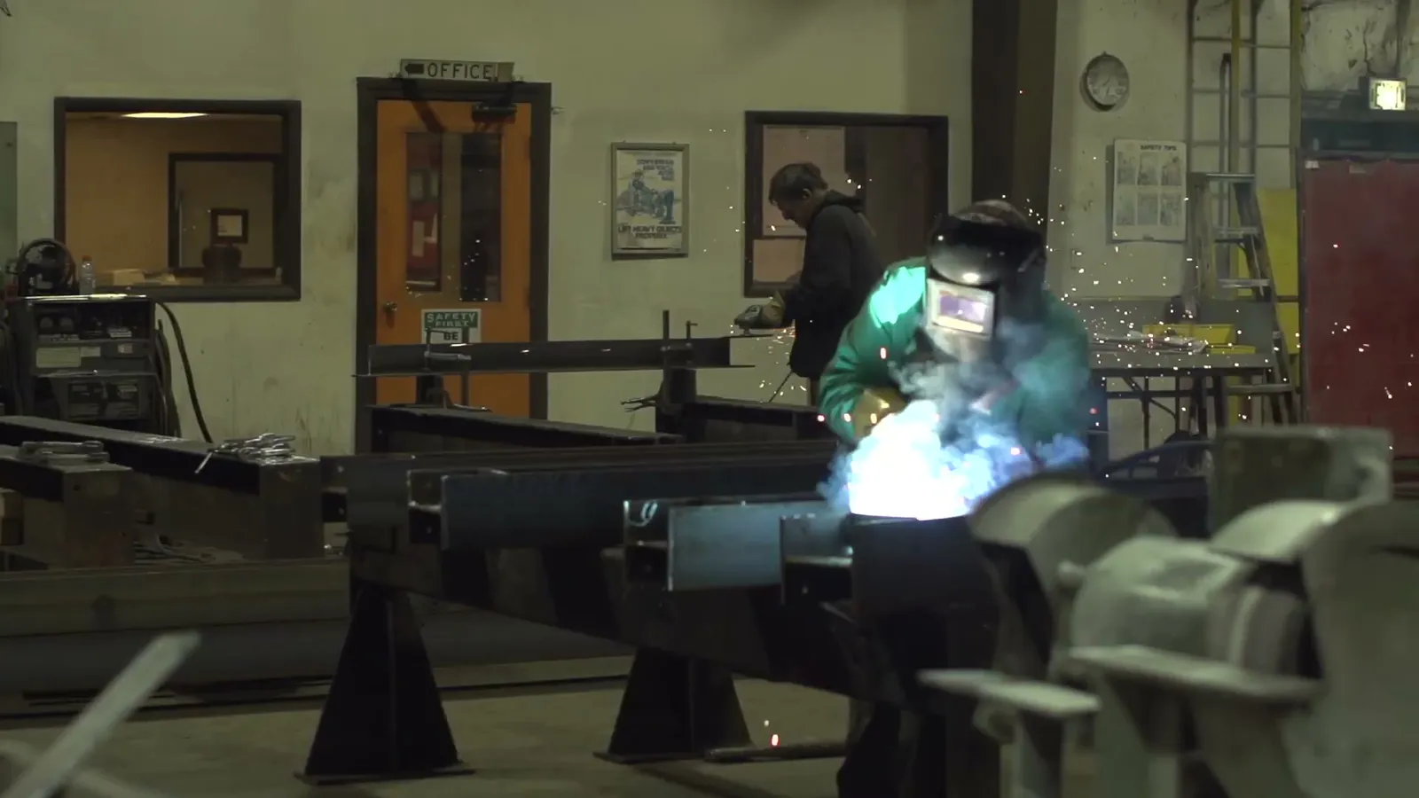 Welder at a fit-up station inside the shop